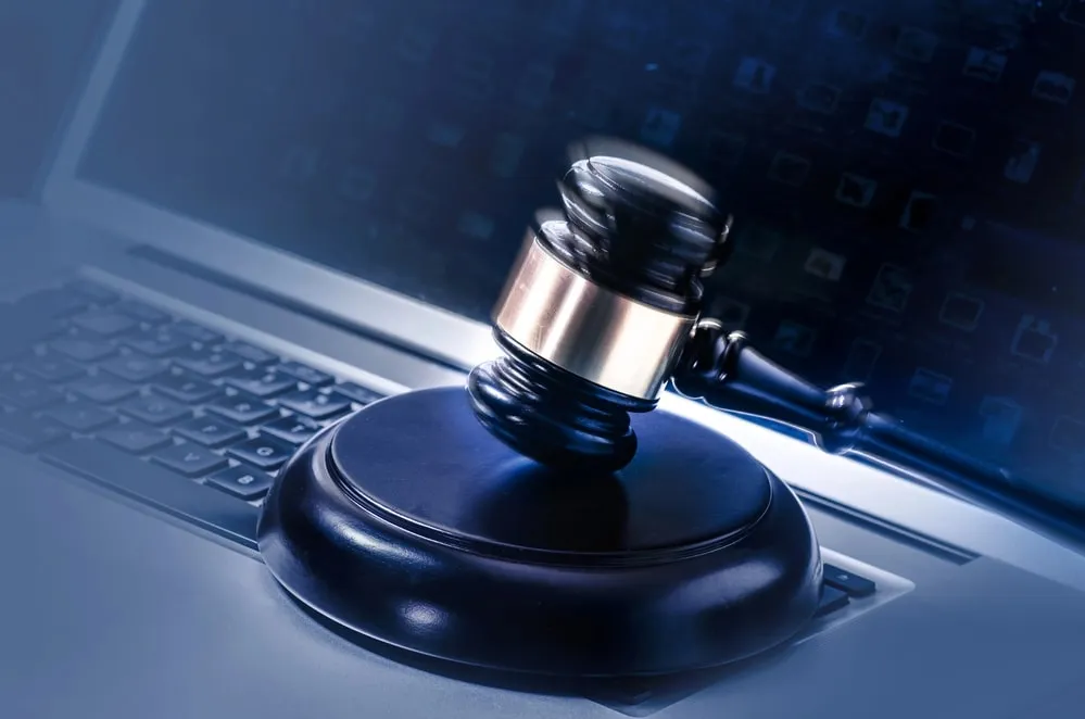 Judge's gavel resting on a laptop keyboard